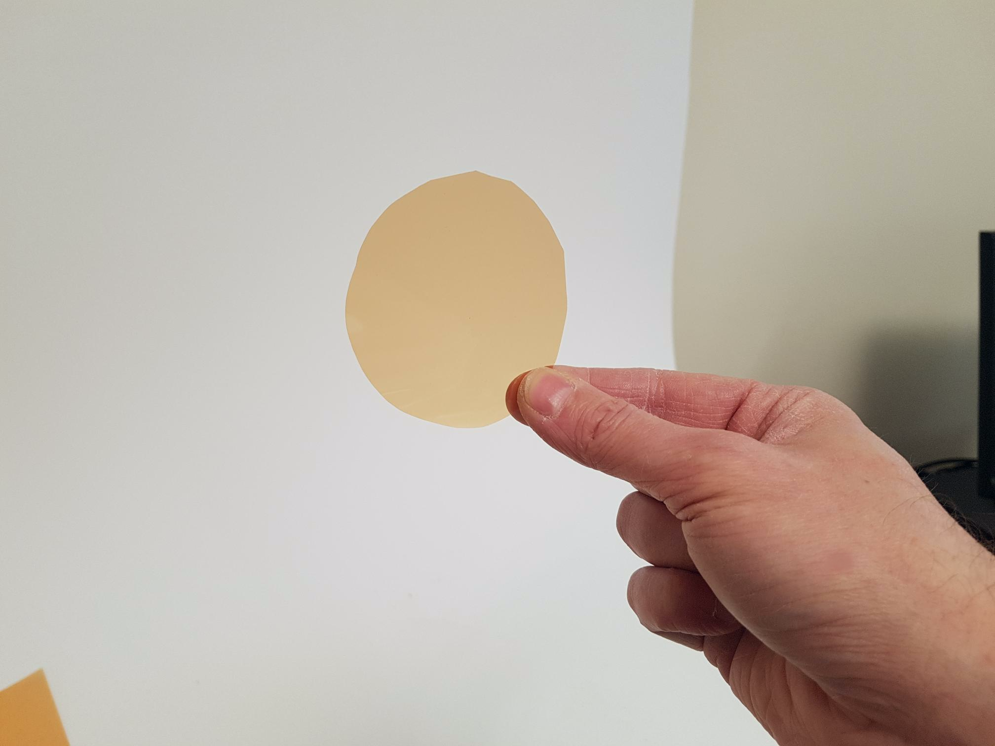 A circle of lighting gel cut to fit a small parcan