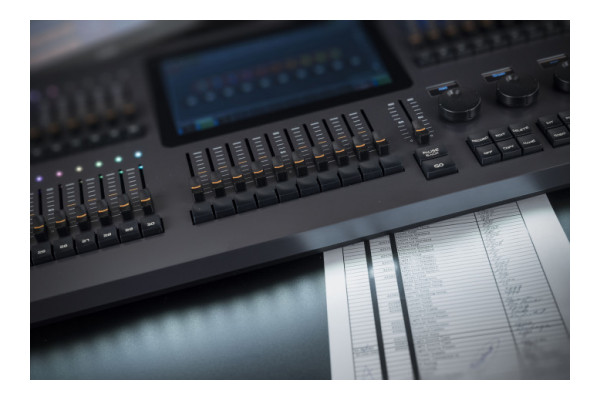 An Image of the Showtec Lampy in a theatrical set up with a queue sheet next to the lighting desk
