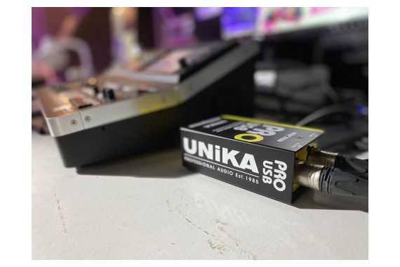 An Image of the UNiKA pro being used next to a Mixing Desk